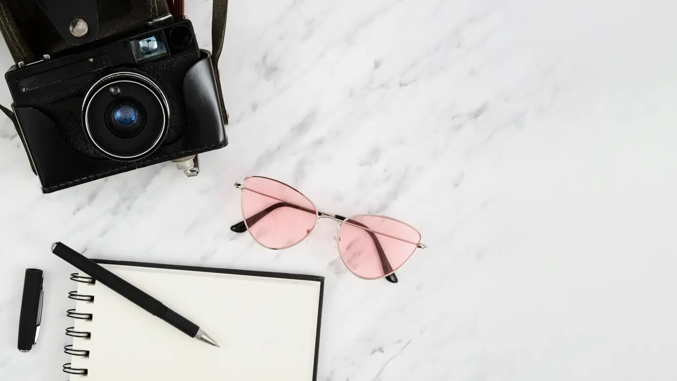 Draufsicht auf eine Retro-Fotokamera mit Notizblock