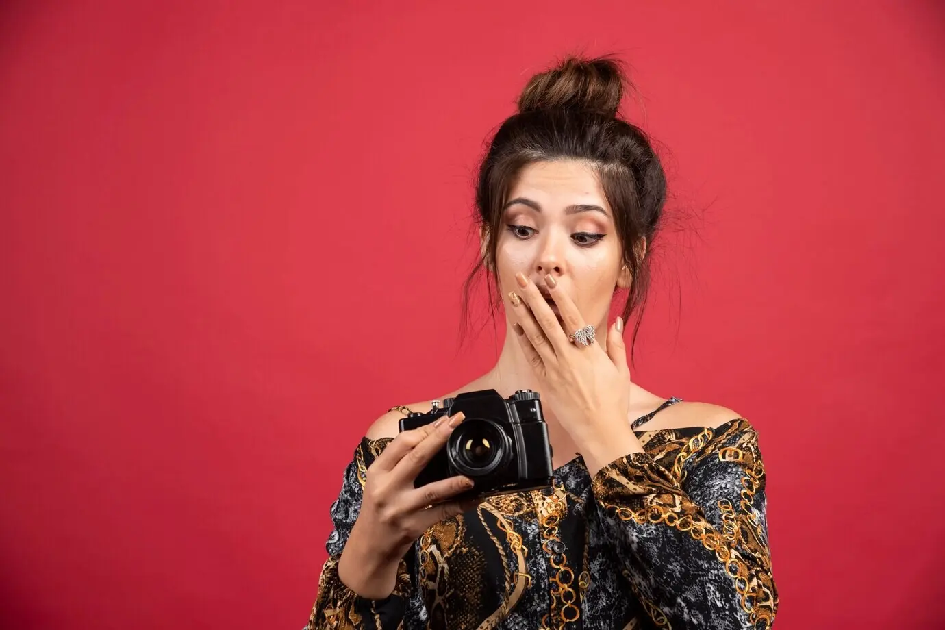 Ein brünettes Mädchen überprüft ihre Fotos auf der Kamera und sieht unzufrieden aus.